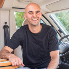 SMV Mitarbeiter Antonio Murolo sitzt lächelnd auf dem Beifahrersitz in einem Wohnmobil.